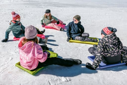 Friends tobogganing at Dinner Plain